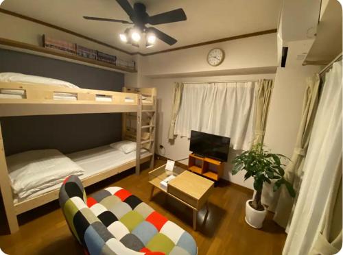 a living room with bunk beds and a couch at Rosemary 203 in Kagoshima