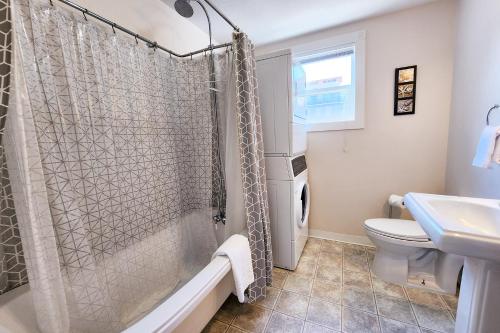a bathroom with a shower and a toilet and a sink at Historic Nye Creek Cottage! in Newport