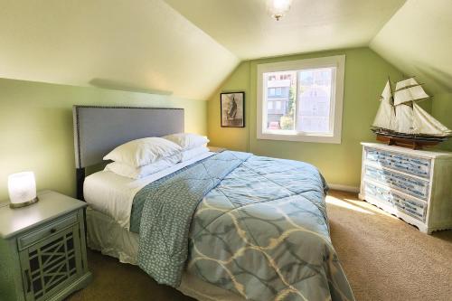a bedroom with a bed and a small window at Historic Nye Creek Cottage! in Newport