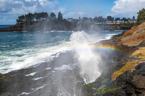 a rainbow on the side of a body of water at Ocean View & Whale Watching! Spouting Horn Three in Depoe Bay