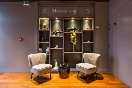 a waiting room with two chairs and a vase of flowers at Midnight Hôtel Paris in Paris