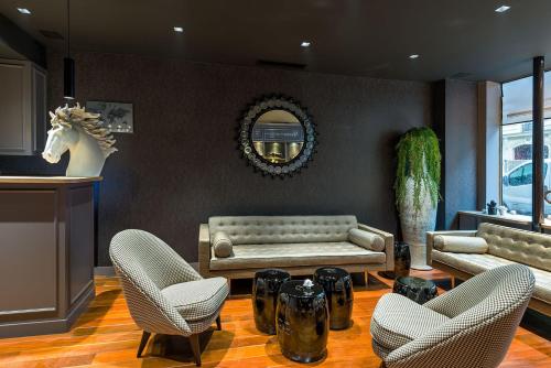 a living room with a couch and a table and chairs at Midnight Hôtel Paris in Paris