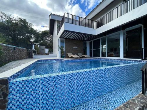 a swimming pool in front of a house at Vista De Montana Private House in Nasugbu