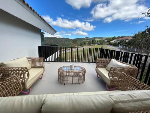 a patio with wicker chairs and a table on a balcony at Vista De Montana Private House in Nasugbu