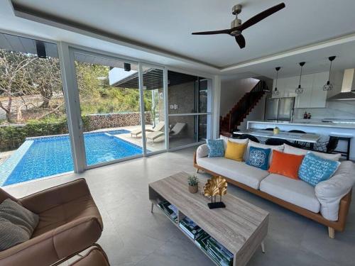 a living room with a couch and a swimming pool at Vista De Montana Private House in Nasugbu