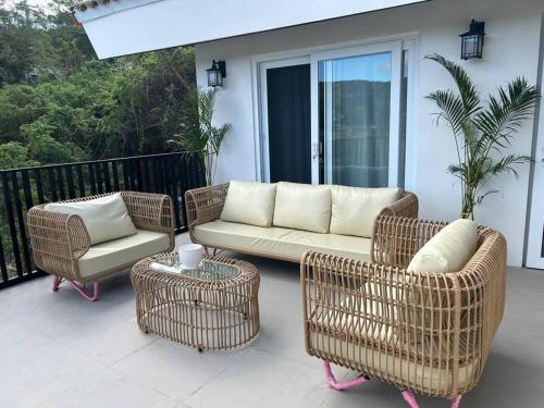 a patio with a couch and chairs on a balcony at Vista De Montana Private House in Nasugbu