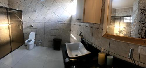 uma casa de banho com um lavatório e um WC em Casa Térrea 3 quartos, sendo 1 suíte Maringá em Maringá