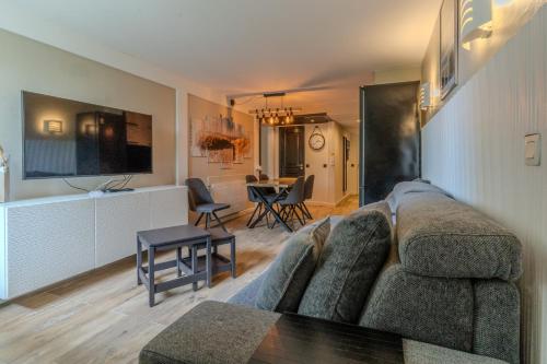 a living room with a couch and a table at Très bel appartement pour 5 pers au coeur du Parc équestre du Touquet in Le Touquet-Paris-Plage