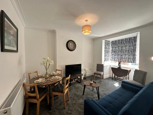 a living room with a blue couch and a table at Spacious Detached Home Close to City with Ample Parking on the Drive in Derby