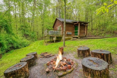 a fire pit in front of a log cabin at Blue Rose Cabins - Big Woody Cabin in Logan