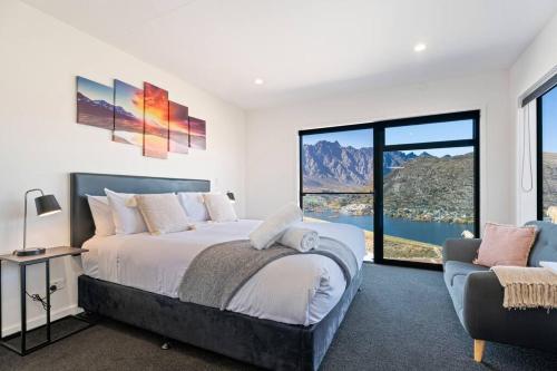 - une chambre avec un lit, un canapé et une grande fenêtre dans l'établissement Style & Tranquillity - Eight Bedrooms, Two Houses, à Queenstown