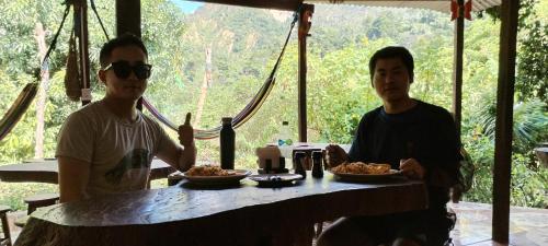 two people sitting at a table with plates of food at Mirador Jungle El Macuti in Rurrenabaque