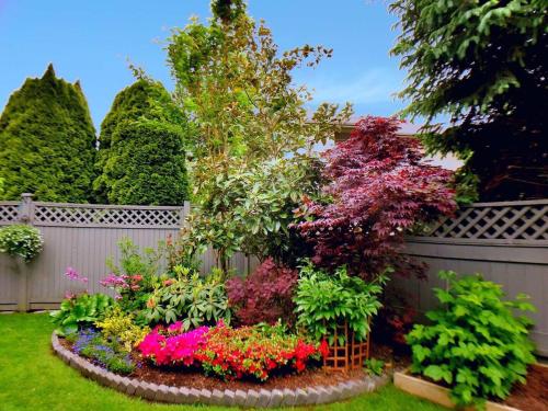 a garden with colorful flowers in a fence at Warm home in Richmond