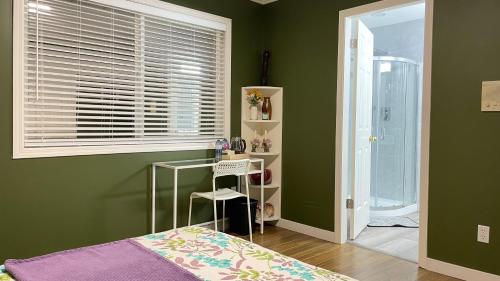 a bedroom with green walls and a bed and a window at Warm home in Richmond