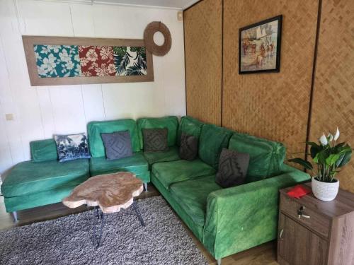 a green couch sitting in a living room at Hinakena Colonial Villa in Papara