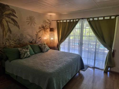 a bedroom with a bed and a large window at Hinakena Colonial Villa in Papara