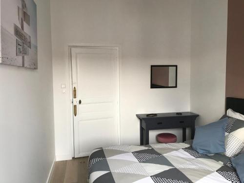 a bedroom with a bed and a desk and a door at Maison de charme rénovée avec piscine, spa et proximité des plages vendéennes - FR-1-426-464 in La Garnache