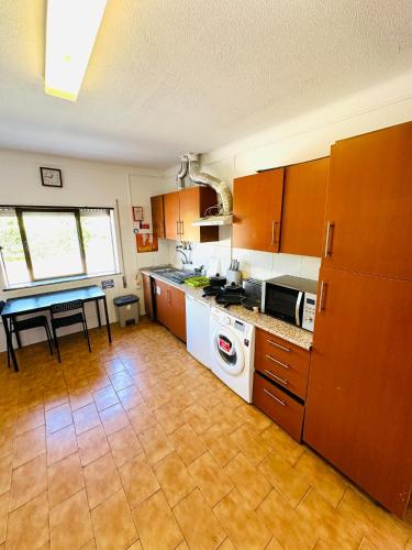 a kitchen with a stove top oven next to a table at Portimao central Holiday Hostel ,Algarve in Portimão