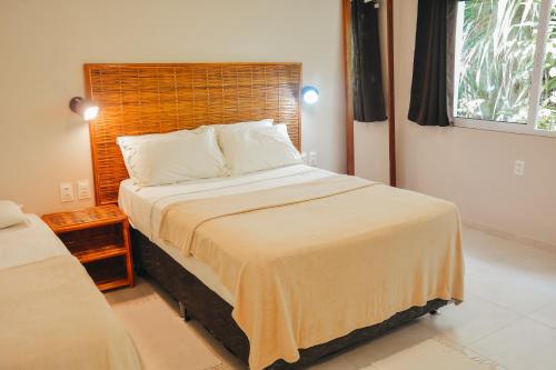 a bedroom with a large bed and a window at Ajubá Pousada in Morro de São Paulo