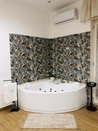 a white bath tub in a room with a wall at Green House GM in Gragnano