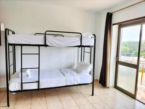 two bunk beds in a room with a window at Portimao central Holiday Hostel ,Algarve in Portimão