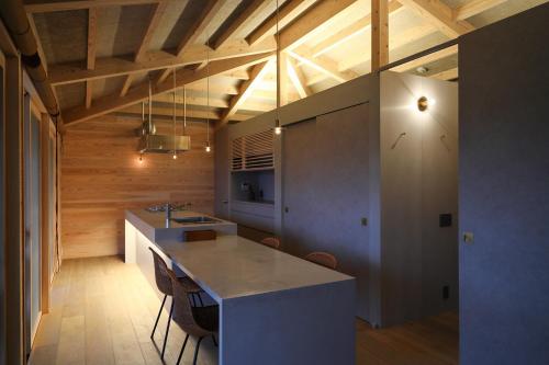 uma cozinha com uma ilha num quarto com tectos em madeira em Ryukyu Villa - Vacation STAY 11908v em Akaoki