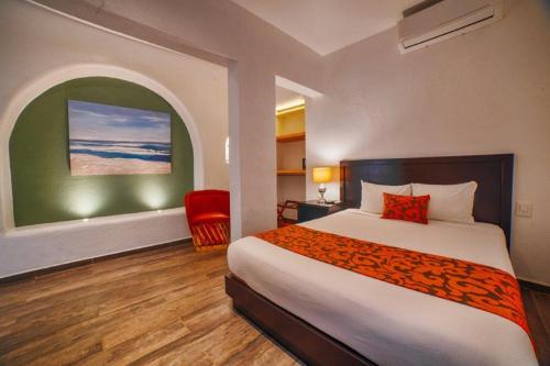 a hotel room with a bed and a red chair at Hotel Casa Tequis San Luis Potosi in San Luis Potosí