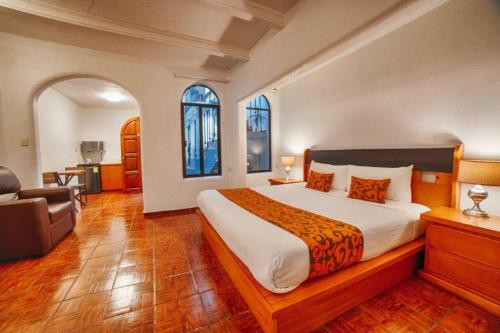 sypialnia z dużym łóżkiem i krzesłem w obiekcie Hotel Casa Tequis San Luis Potosi w mieście San Luis Potosí
