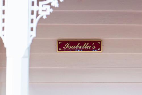 a sign on the side of a pink wall at Isabellas At Beechworth in Beechworth