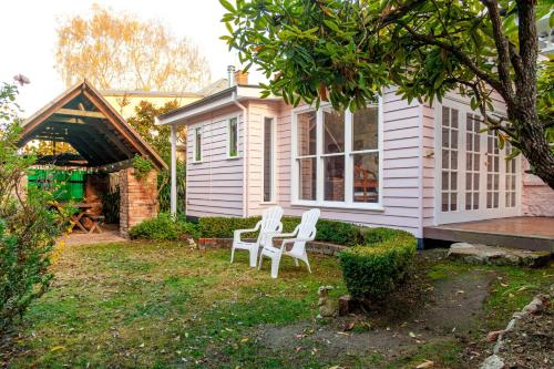 two white chairs in the yard of a house at Isabellas At Beechworth in Beechworth