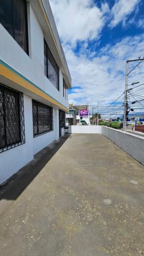 een lege parkeerplaats naast een wit gebouw bij Departamento Bien Ubicado con todo lo necesario in Latacunga