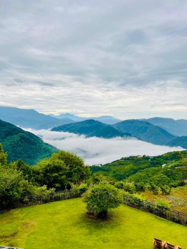 a green field with a view of the mountains at Junyi Landscape Villa in Renai