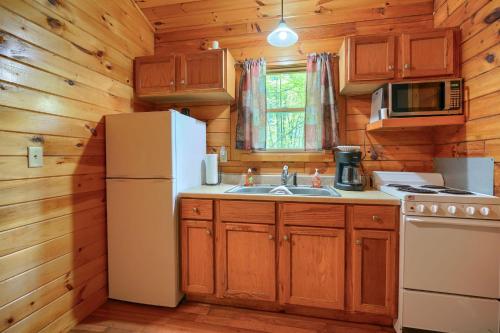 a kitchen with a refrigerator and a sink at Blue Rose Cabins - Cupids Cabin in Logan