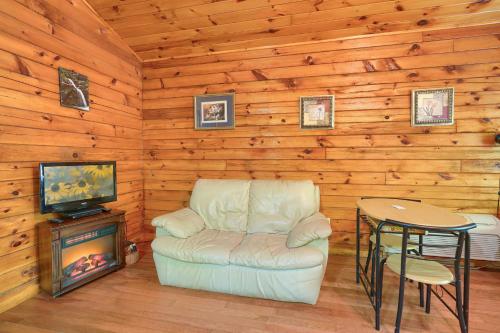 a living room with a couch and a tv and a table at Blue Rose Cabins - Cupids Cabin in Logan