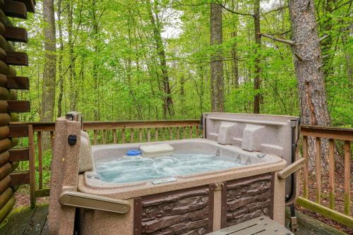 a jacuzzi tub on a deck in the woods at Blue Rose Cabins - Cupids Cabin in Logan