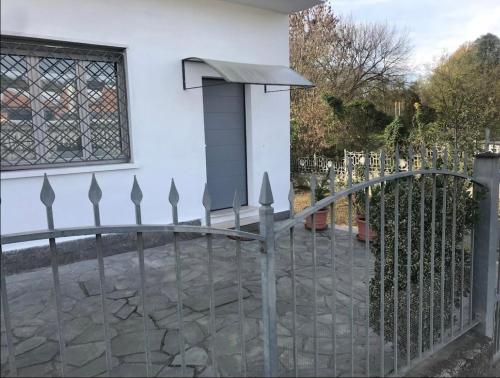 una valla metálica frente a un edificio blanco en Casa Story 2 è un piccolo gioiello en Asti