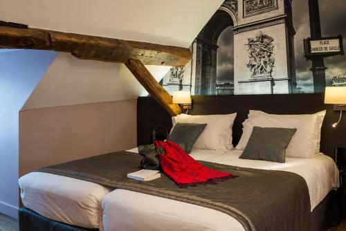 a bedroom with a large bed with a red blanket on it at Midnight Hôtel Paris in Paris