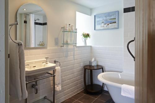 Y Meirionnydd Townhouse في دولغيلوو: حمام مع حوض ومغسلة وحوض استحمام