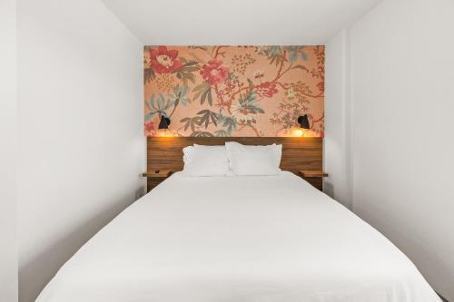 a bedroom with a white bed and a floral wallpaper at Uptown Inn by Vantaggio Suites in San Diego
