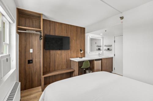 a bedroom with a white bed and a desk at Uptown Inn - Limited Service Apart-Hotel in San Diego