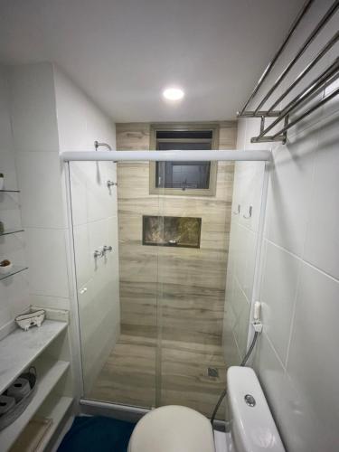uma casa de banho com uma cabina de duche em vidro e um WC. em Loft Condado Mangaratiba em Mangaratiba