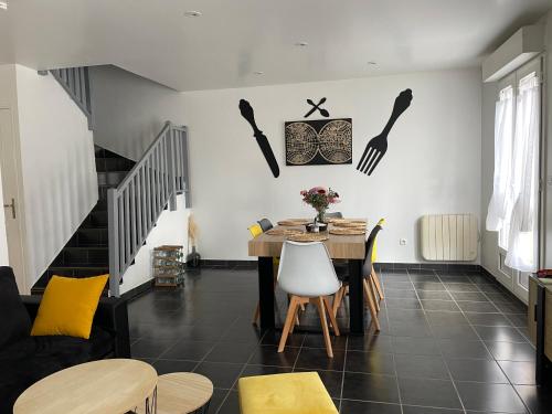 sala de estar con mesa y sillas y escalera en Maison entière 5 mn Roissy CDG/15 mn Parc Astérix en Le Mesnil-Amelot
