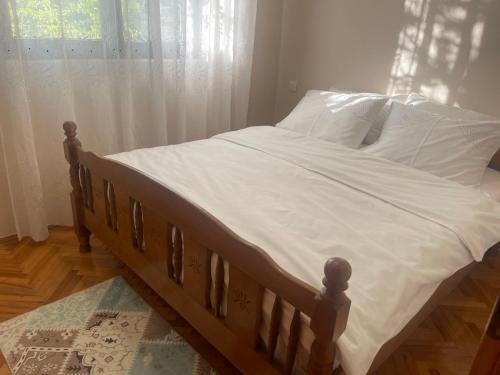 a bed with white sheets and pillows in a bedroom at Green Cottage in Podgorica