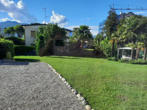 a backyard with a grass yard and a house at Casa Silvia in Germignaga