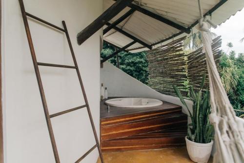 een badkamer met een hangmat en een bad bij Pousada Sossego in Pipa