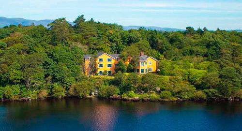 a house on an island in the middle of a lake at Carrig Country House & Restaurant in Killorglin