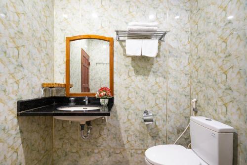 a bathroom with a toilet and a sink and a mirror at CAMY Hotel Vung Tau in Vung Tau