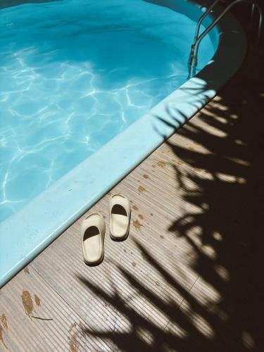 a swimming pool with a pair of shoes in the water at Pousada Sossego in Pipa