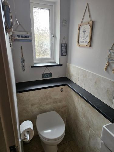 a bathroom with a white toilet and a window at Midway in Shepton Mallet