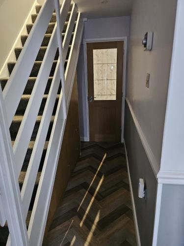 a stairway with a white rail and a door at Midway in Shepton Mallet